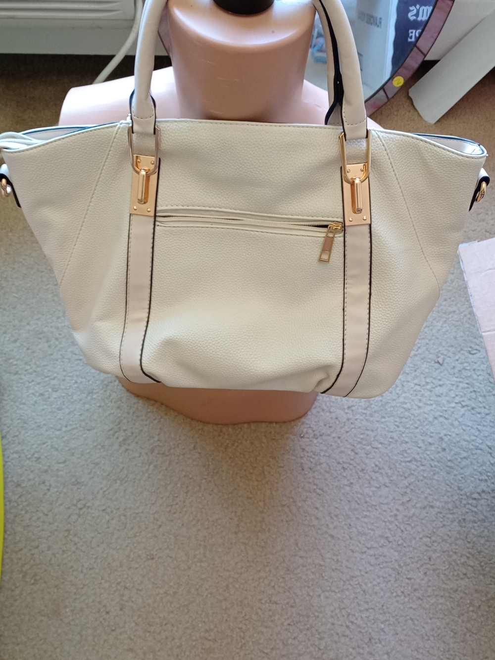 beige Mia K. Collection tote bag with gold hardware details.